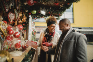 Couple looking at a gift to buy from a stall at the Christmas market