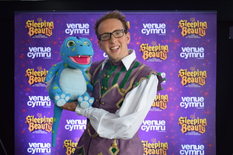 Cast member from sleeping beauty panto posing for a photo with his puppet