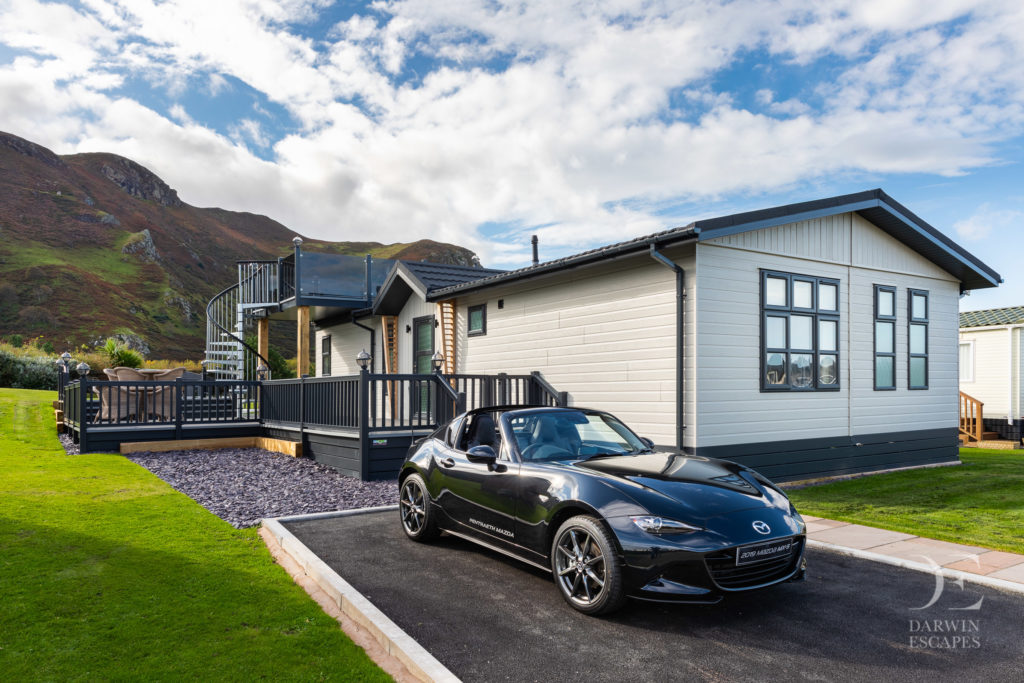 Exterior shot of the Bowmoor lodge and a Mazda MX5