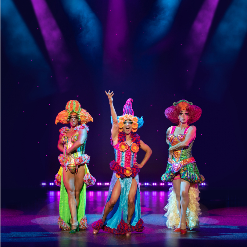 Three cast members of the Priscilla Queen of the Desert posing for a photo