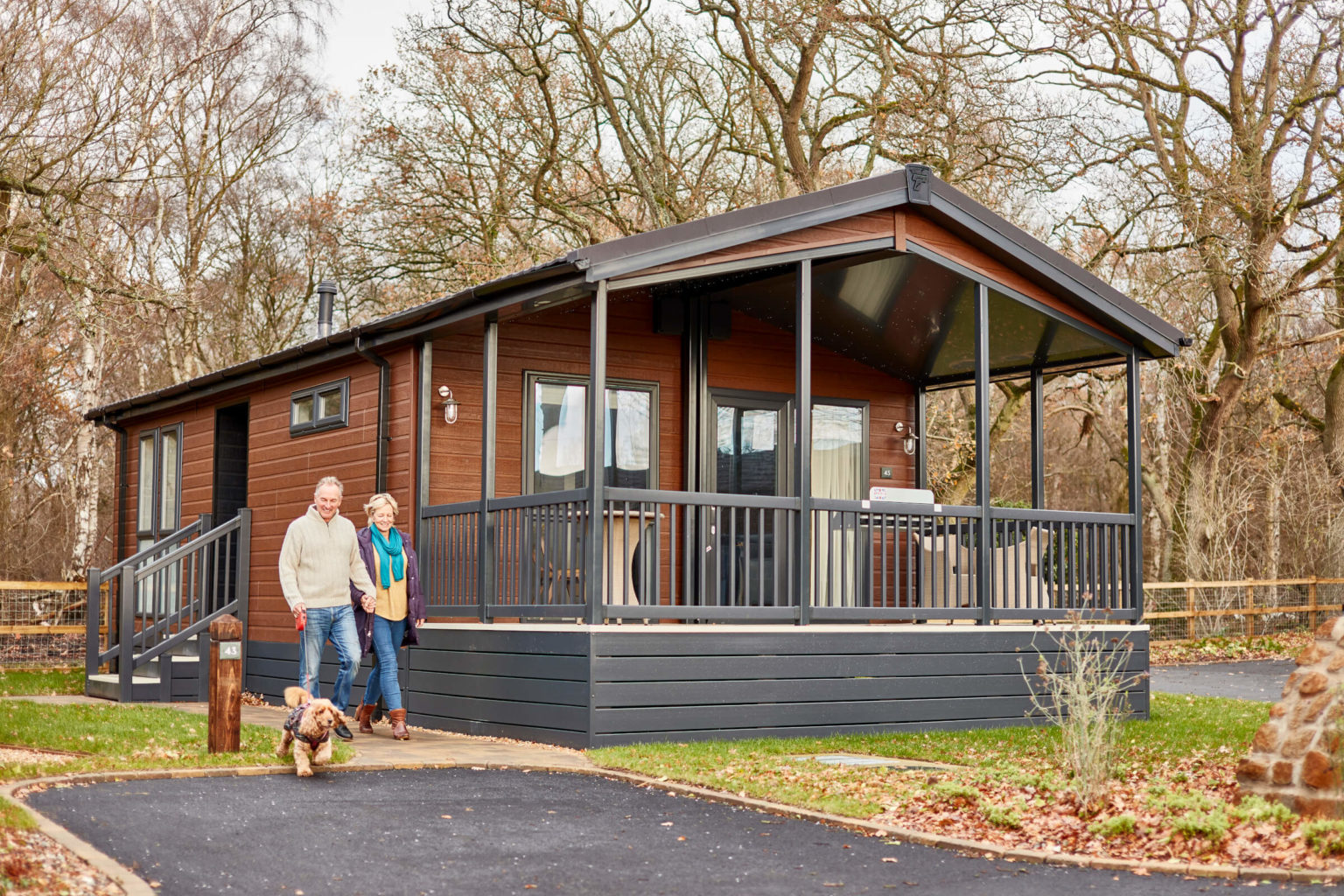couple walking their dog outside a lodge