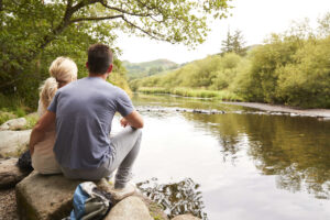 couple sat on rocks near waters edge in the Lake District