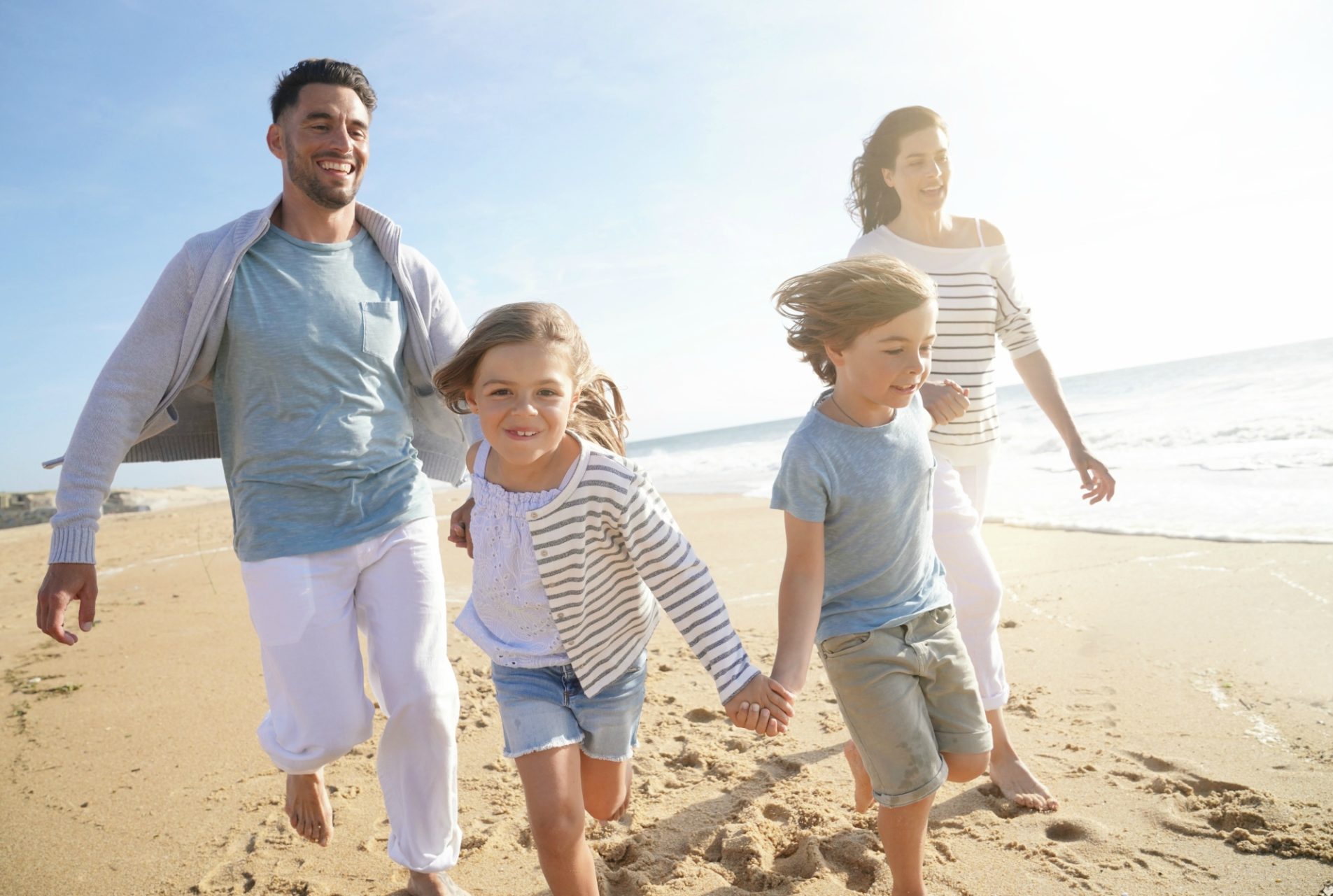 happy family holding hands on the beacha