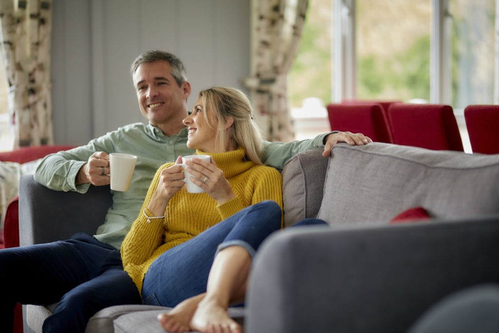 couple on lodge sofa enjoying a drink