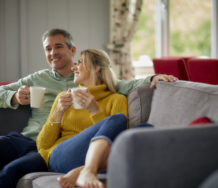 couple on lodge sofa enjoying a drink