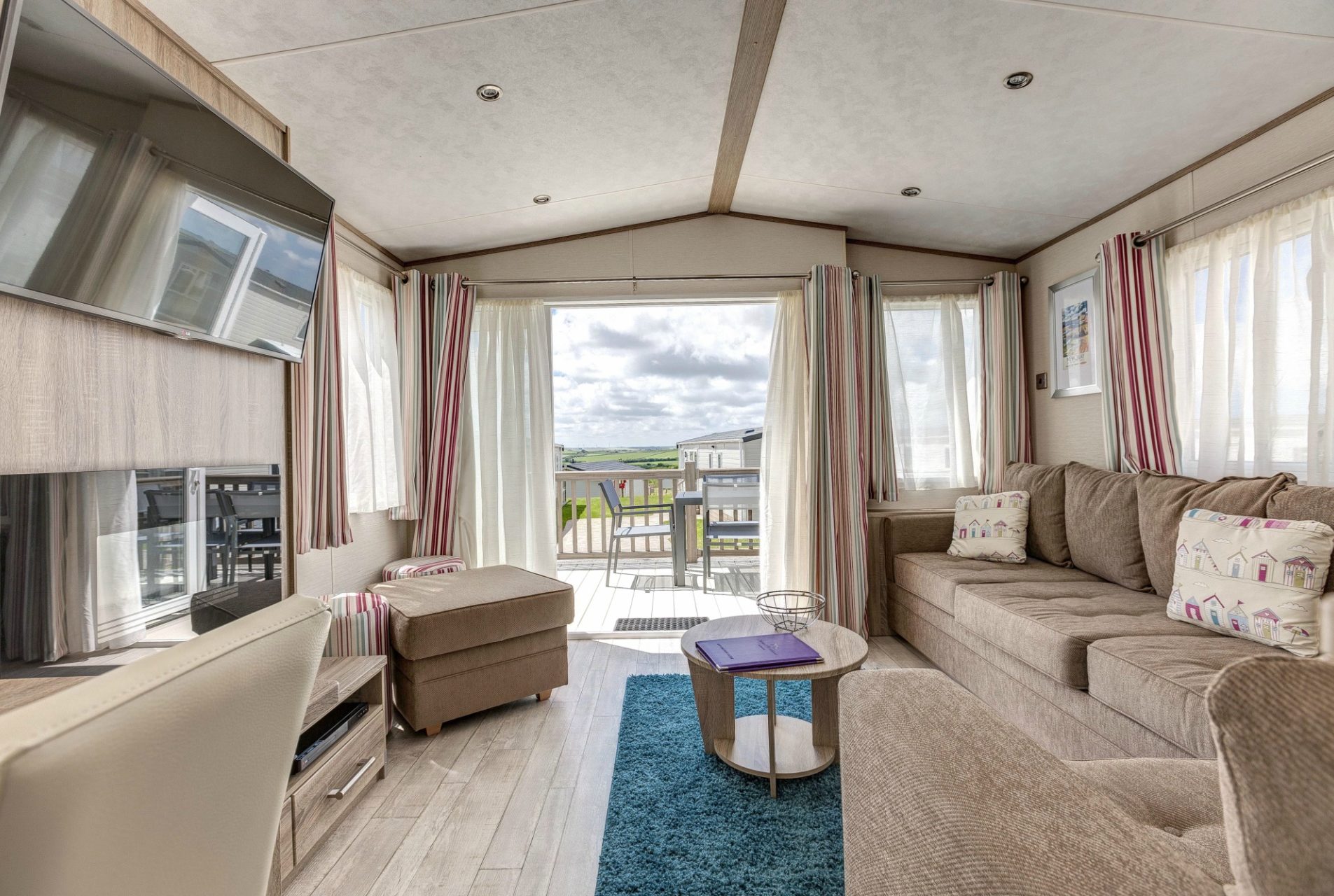 caravan lounge with open patiodoors leading to decking