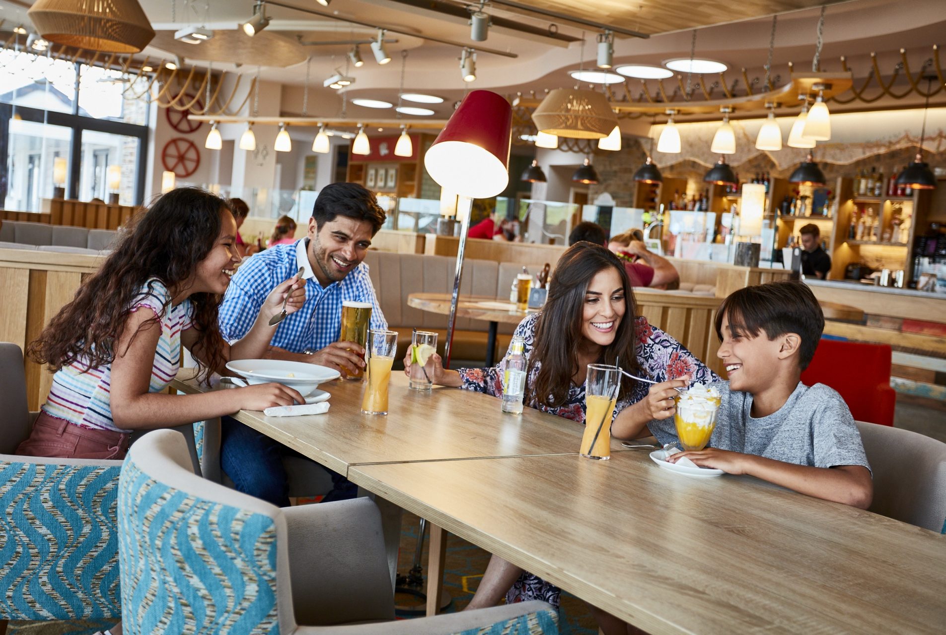 family with young teens enjoy drinks in a modern bistro setting