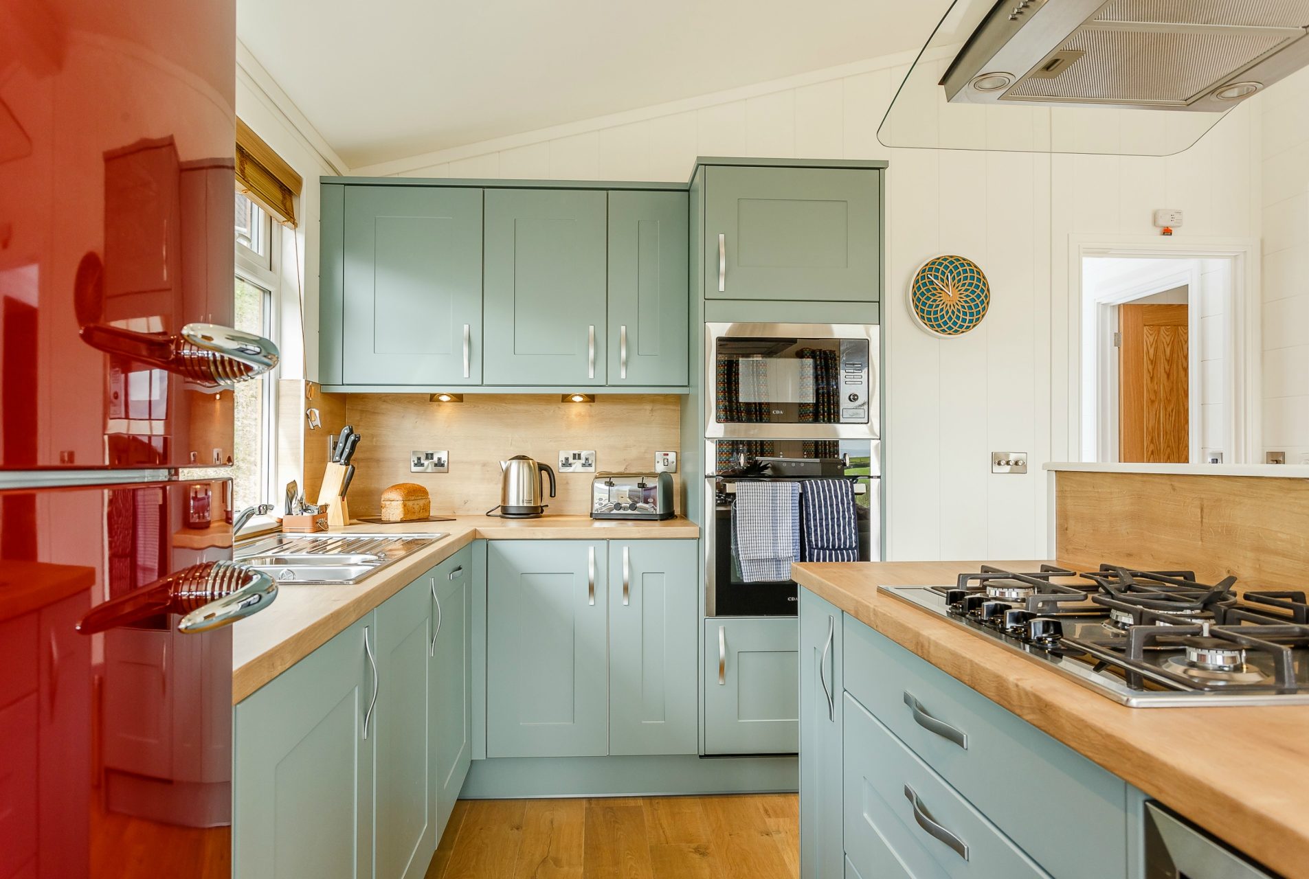 Modern duck egg kitchen units and red fridge freezer