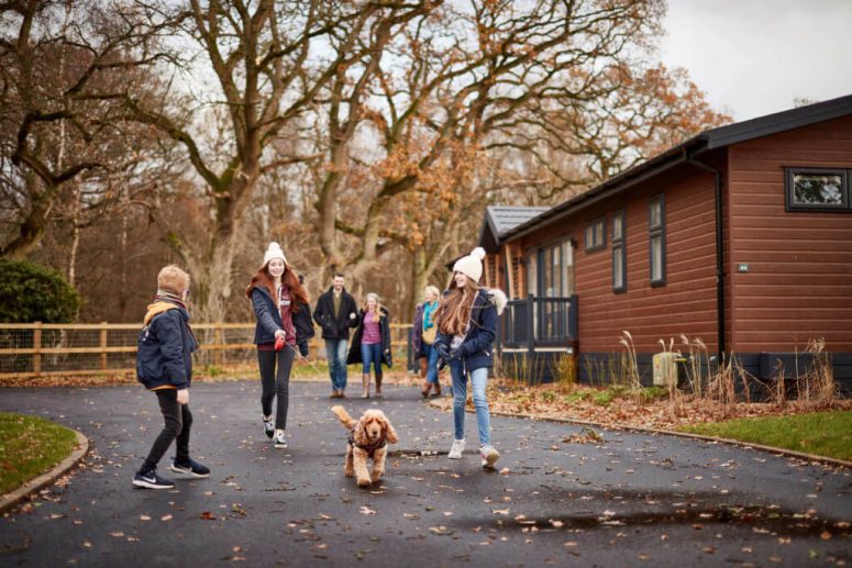 Family walking their pet dog through Norfolk Woods Resort & Spa