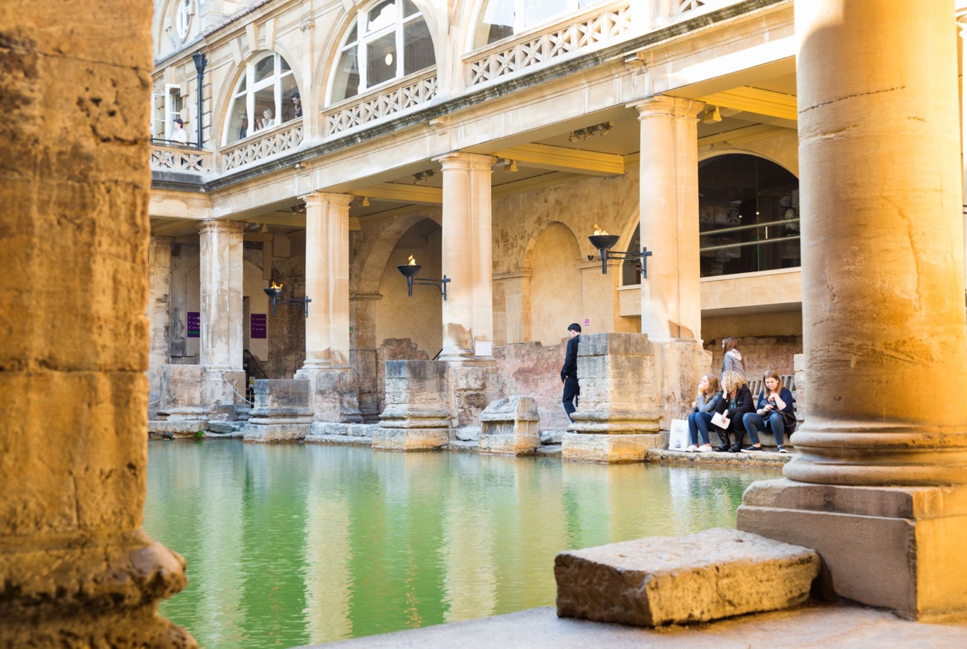 Roman bath house with huge colums, statues and green waters