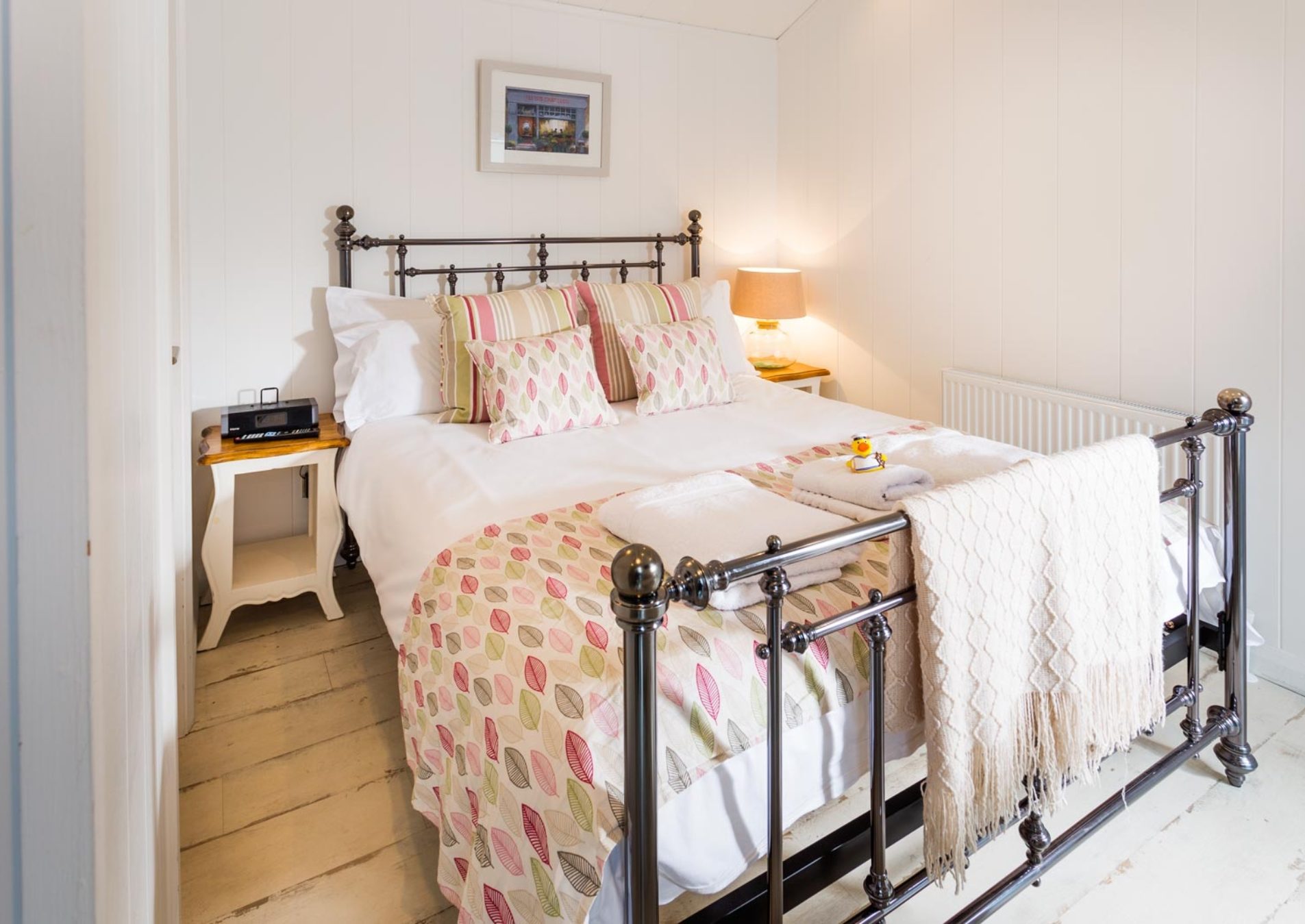 shabby chic style bedroom with iron framed bed and colourful bedding