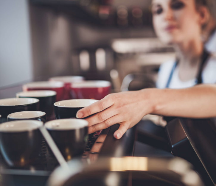 A close up picture of a bar staff member selecting a mug