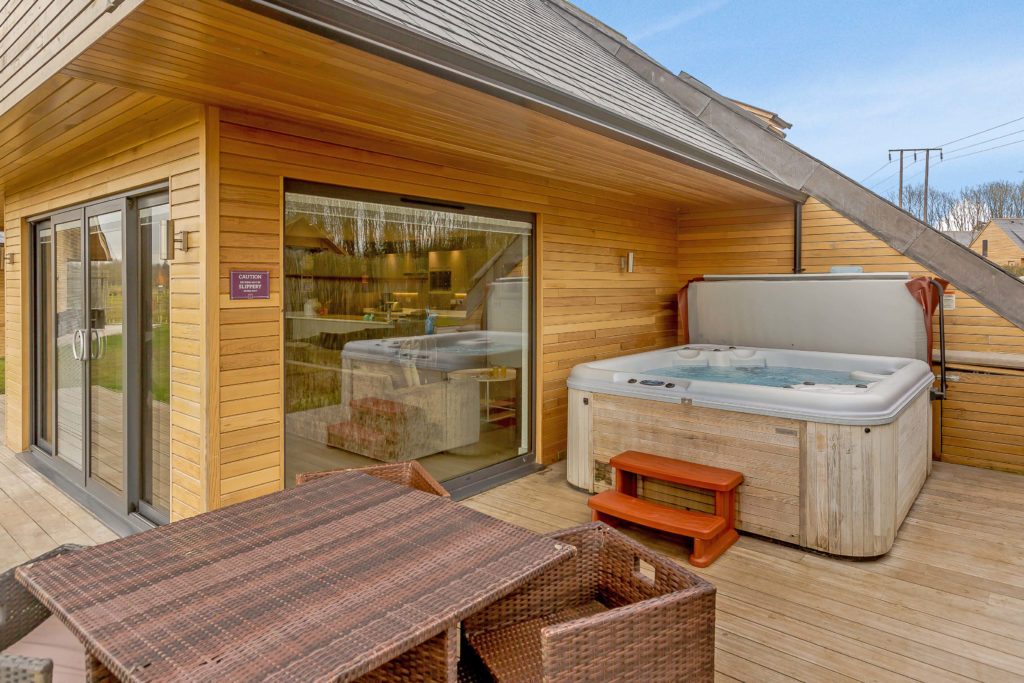 lodge exterior with table and open hot tub